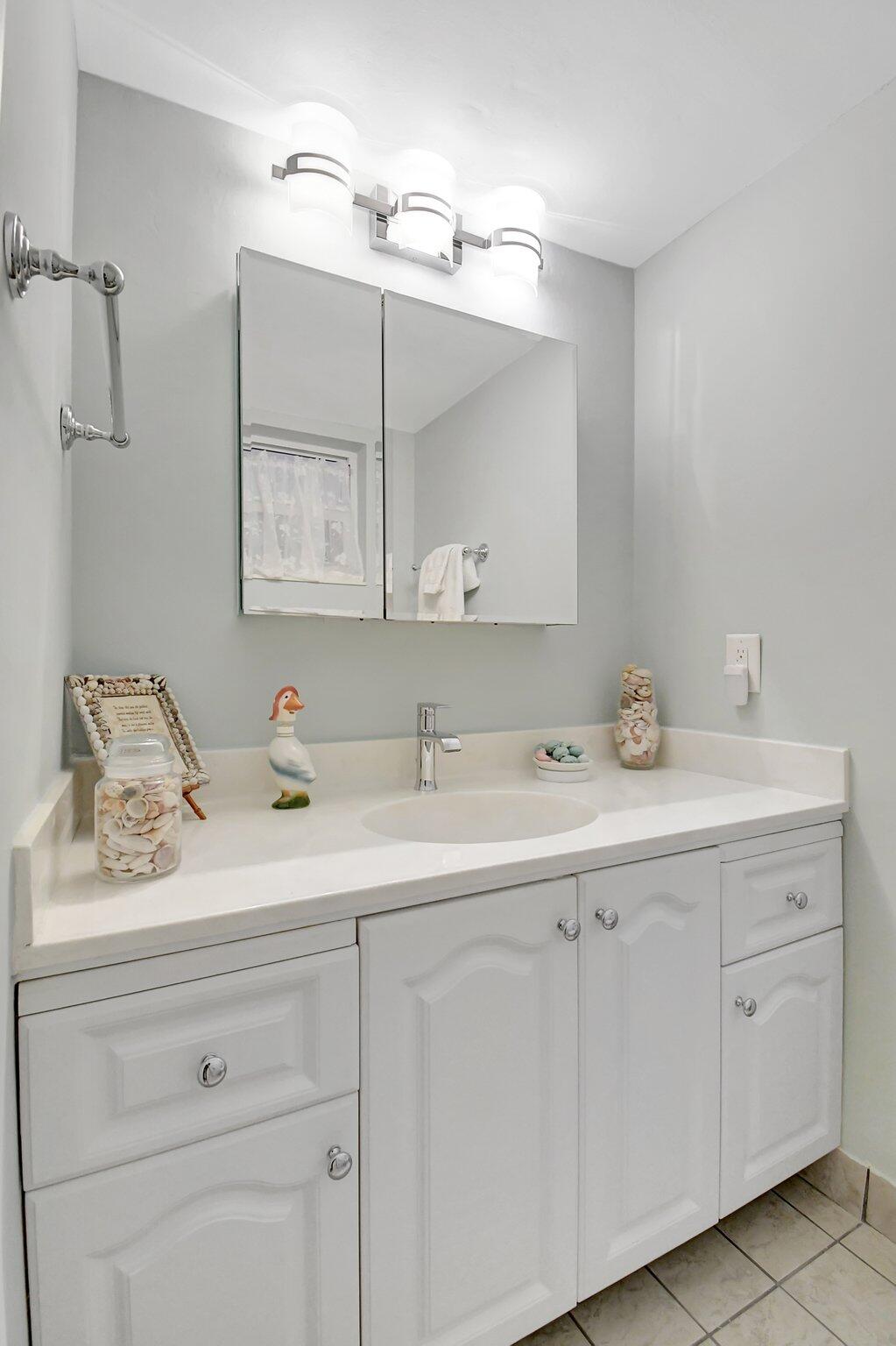 1481 South Ocean Boulevard, Unit 413A Lauderdale-by-the-Sea, FL 33062 - Photo 25 of 48 a bathroom with a sink and a mirror