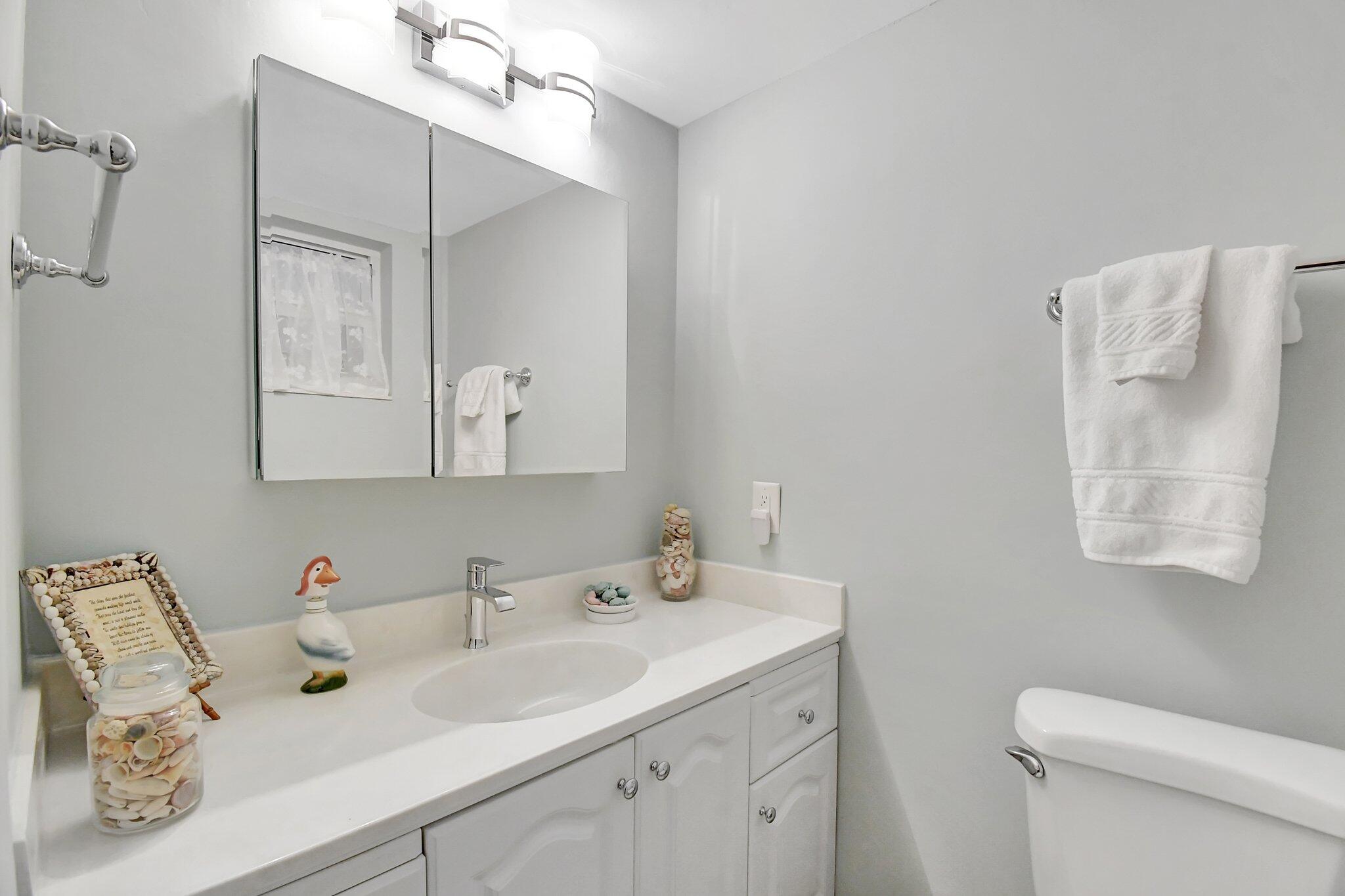 1481 South Ocean Boulevard, Unit 413A Lauderdale-by-the-Sea, FL 33062 - Photo 26 of 48 a bathroom with a sink toilet and mirror