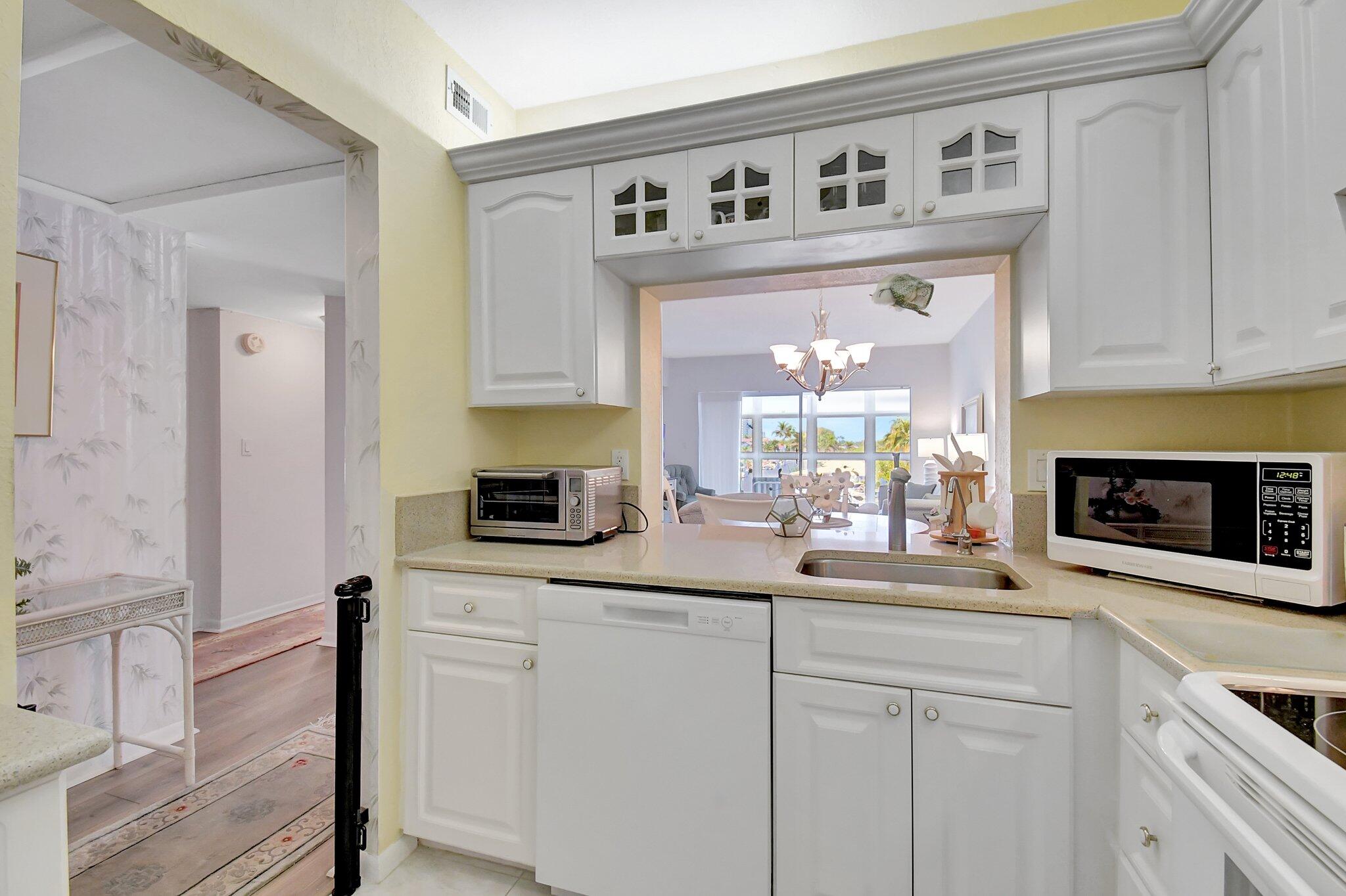1481 South Ocean Boulevard, Unit 413A Lauderdale-by-the-Sea, FL 33062 - Photo 6 of 48 a kitchen with cabinets and window