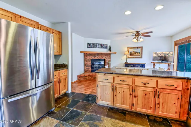 a kitchen with stainless steel appliances granite countertop a refrigerator a stove and a sink with cabinets