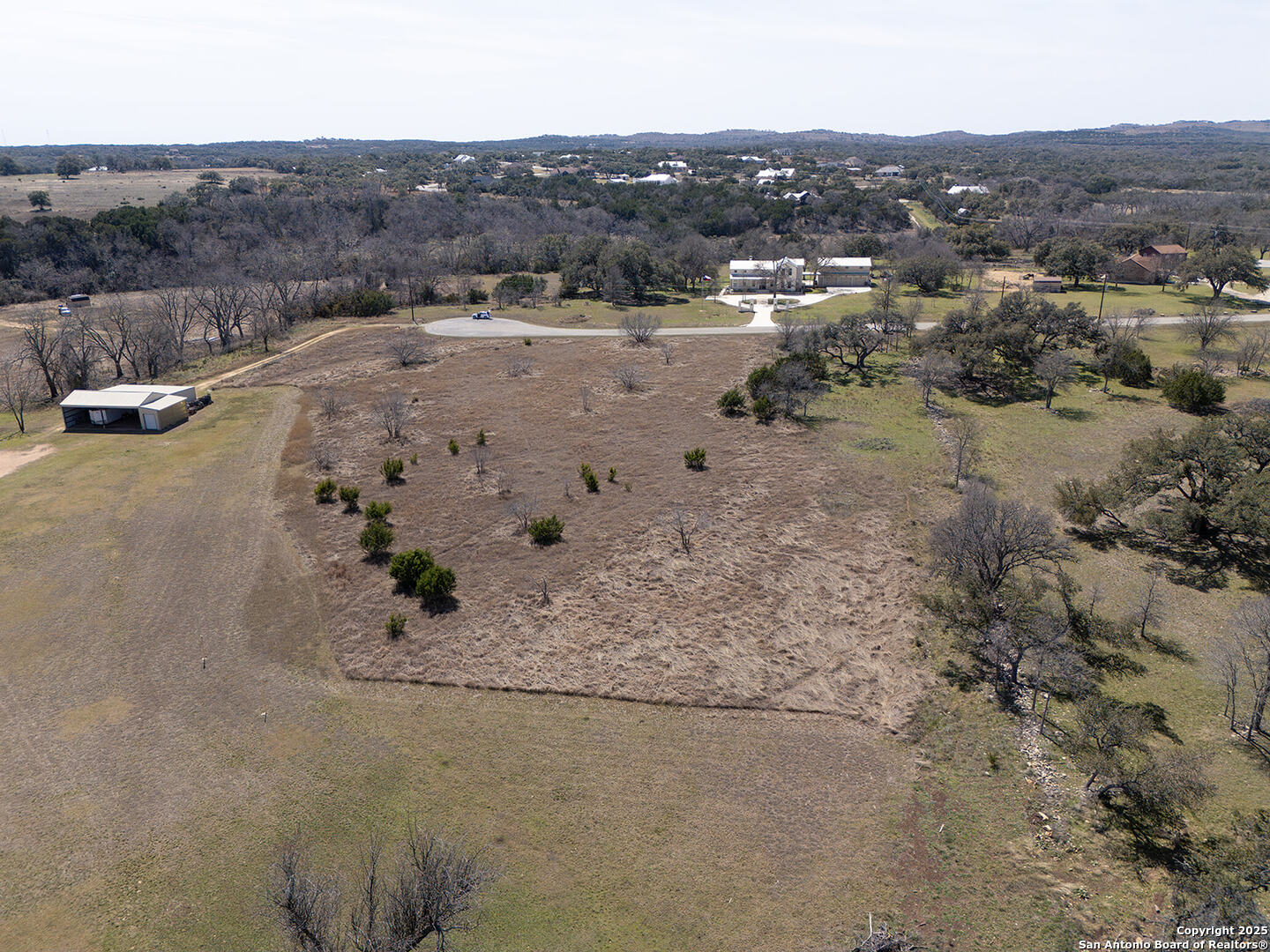 Lot 128 Rio Grande Drive Blanco, TX 78606 - Photo 2 of 9 a view of a dry field with mountains in the background