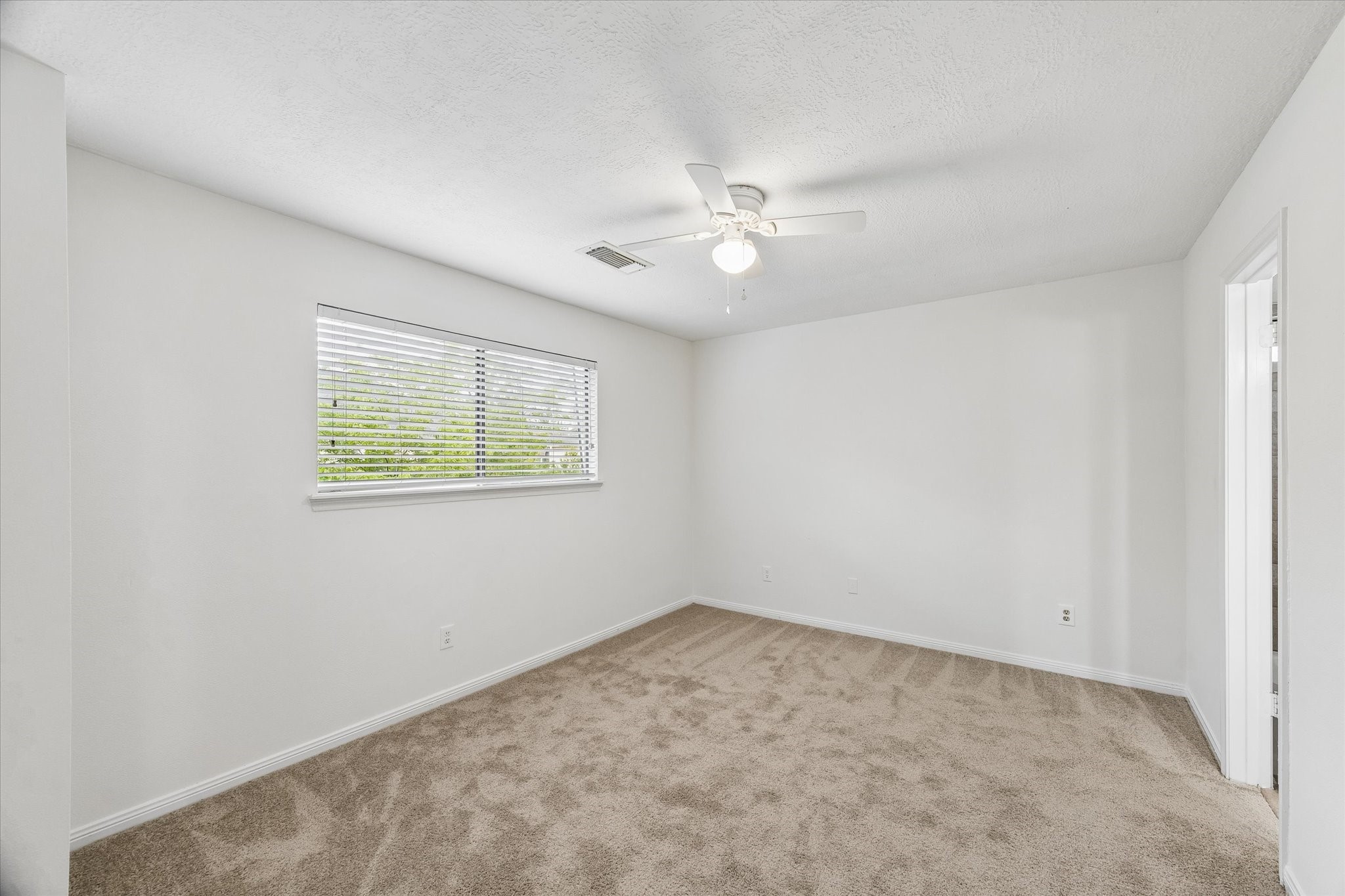17902 Fernbluff Drive Spring, TX 77379 - Photo 20 of 29 an empty room with a window and ceiling fan