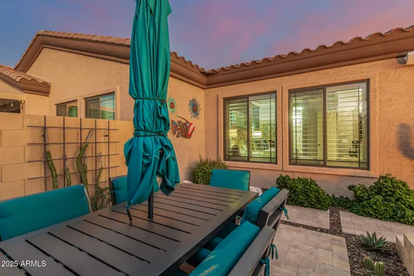 a view of a swimming pool with lawn chairs floor to ceiling window and lake view