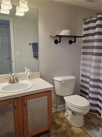 a bathroom with a sink a toilet and a mirror