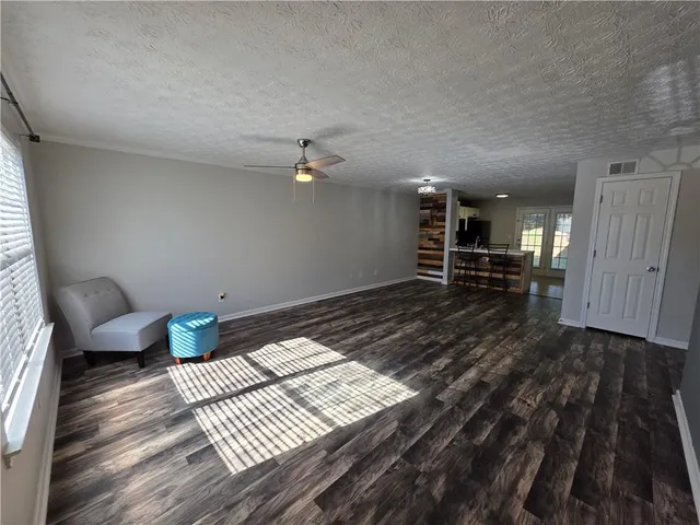 a view of a bedroom with wooden floor and furniture