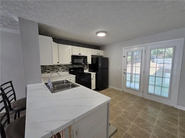 a kitchen with kitchen island a counter top space appliances and a cabinets