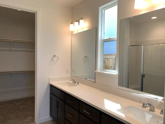 a bathroom with a double vanity sink and a mirror