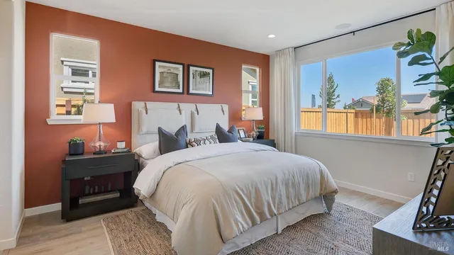 a bedroom with a large bed and windows