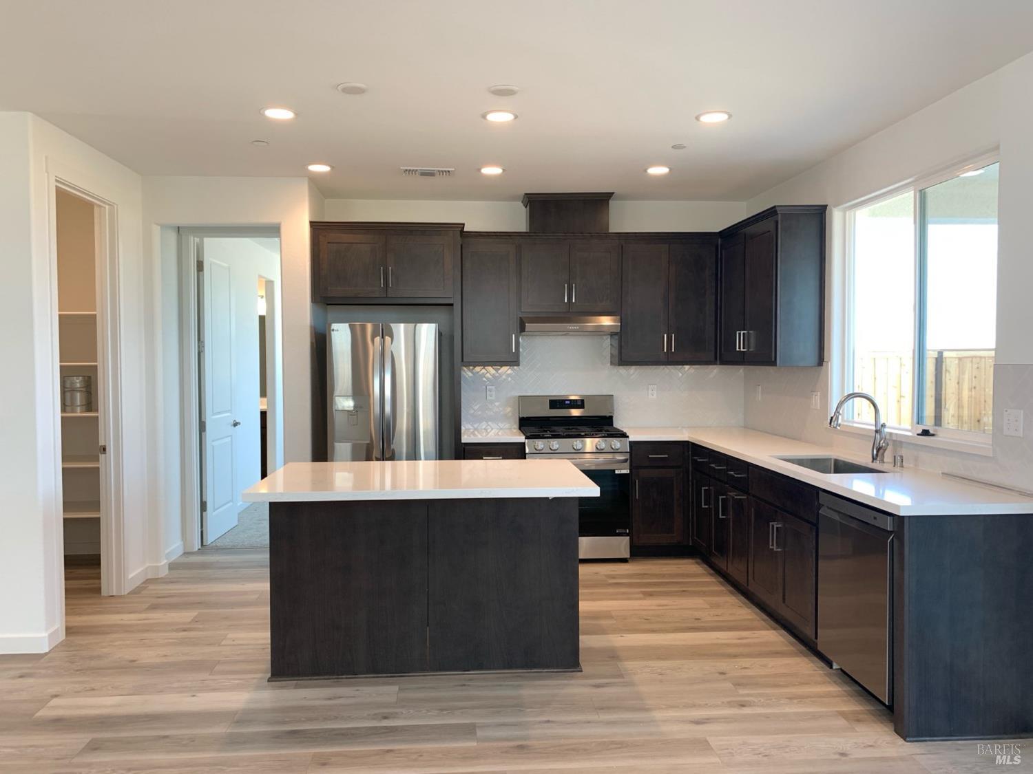 2640 Hopscotch Street Rio Vista, CA 94571 - Photo 3 of 51 a large kitchen with stainless steel appliances granite countertop a stove a sink dishwasher a refrigerator and white cabinets with wooden floor