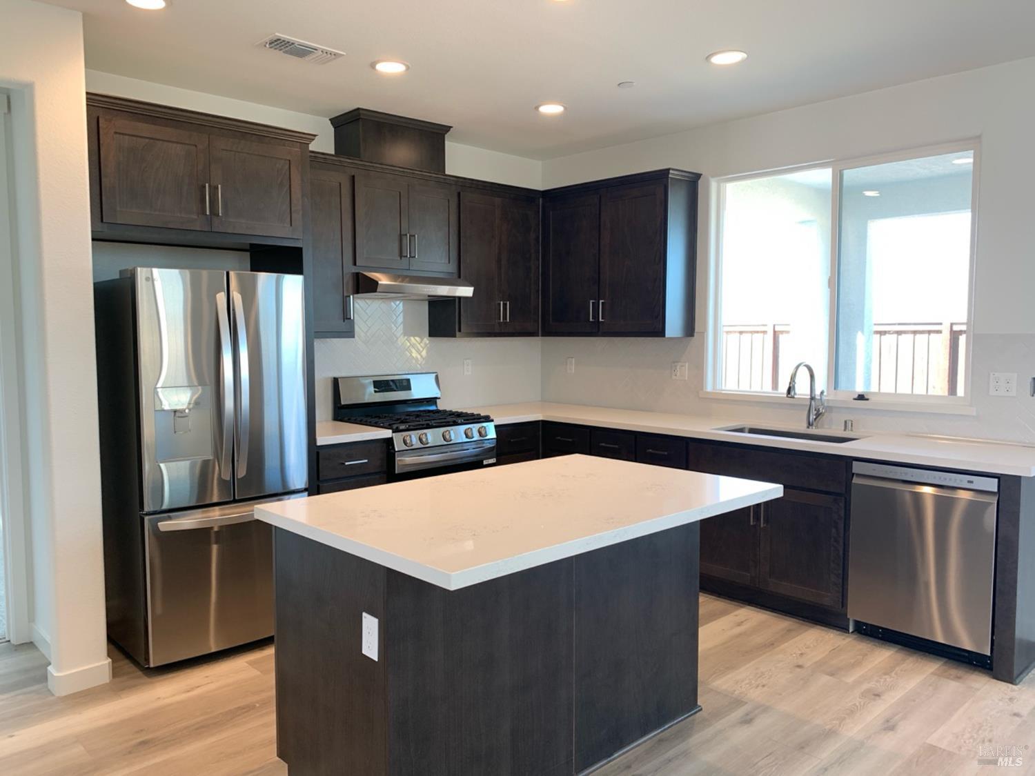 2640 Hopscotch Street Rio Vista, CA 94571 - Photo 4 of 51 a kitchen with stainless steel appliances granite countertop a refrigerator a sink a stove a microwave and wooden cabinets