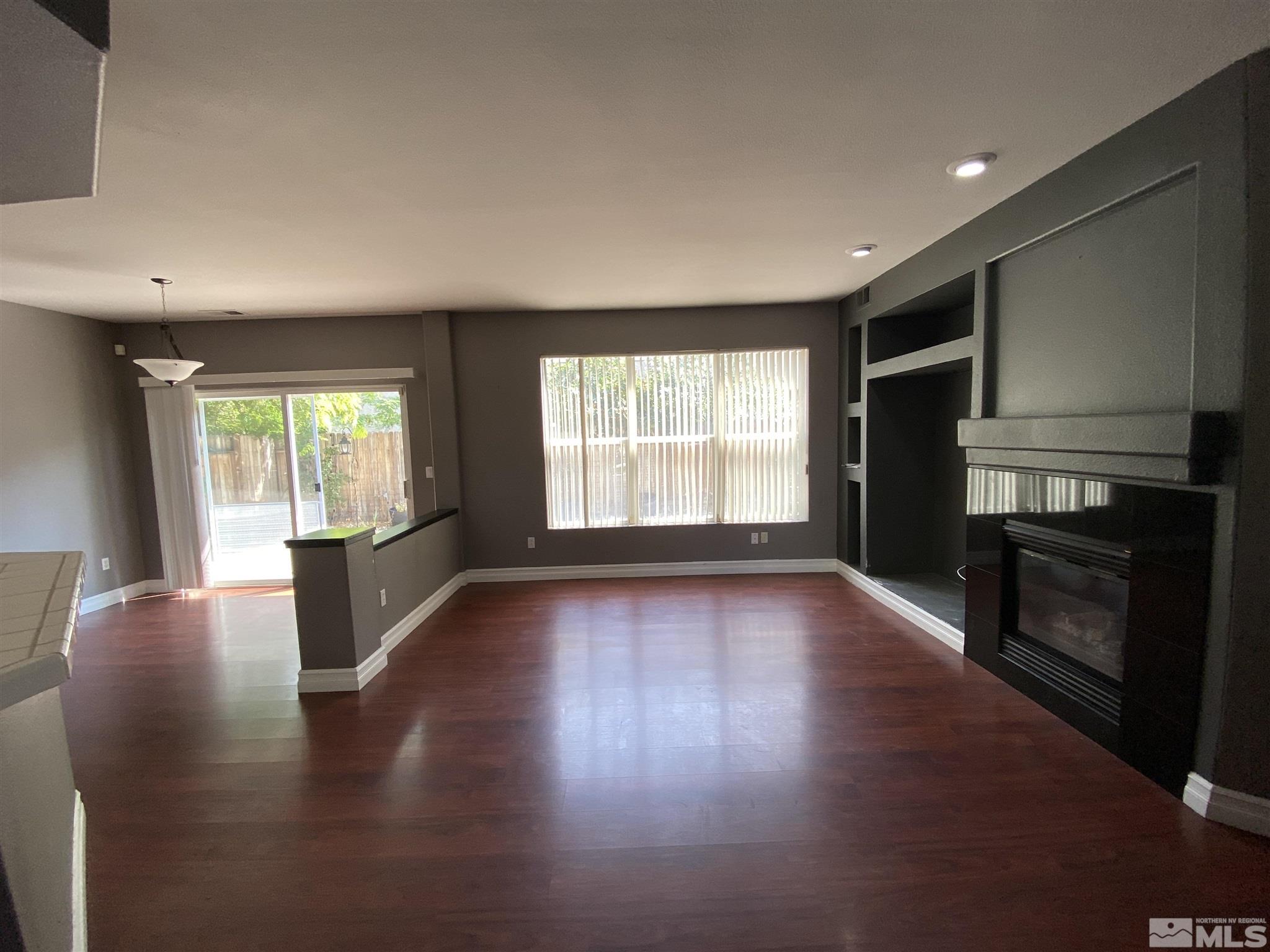 9636 Truckee Meadows Place Reno, NV 89521 - Photo 2 of 21 an empty room with wooden floor and fireplace