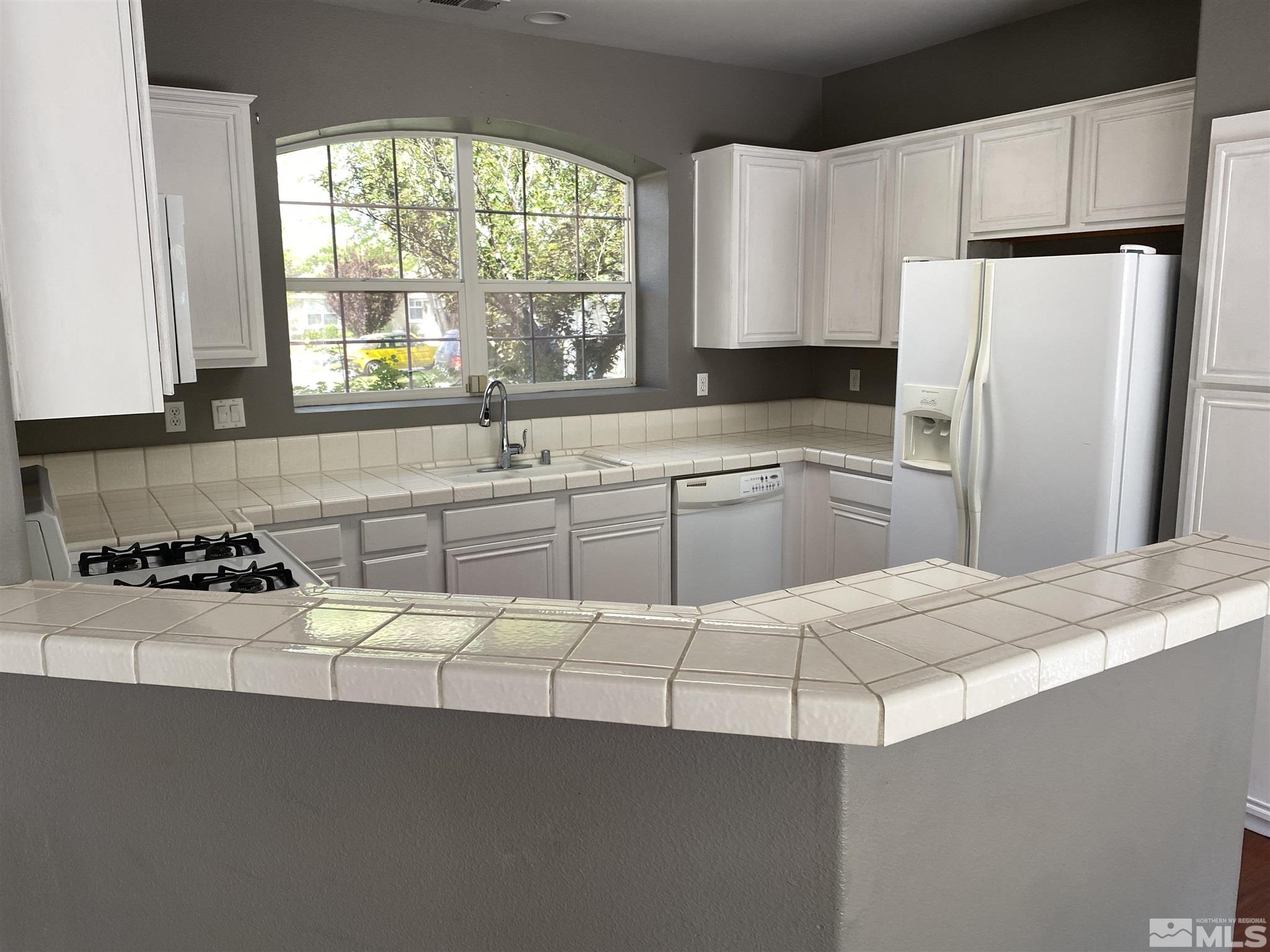9636 Truckee Meadows Place Reno, NV 89521 - Photo 3 of 21 a kitchen with a sink a stove and a refrigerator