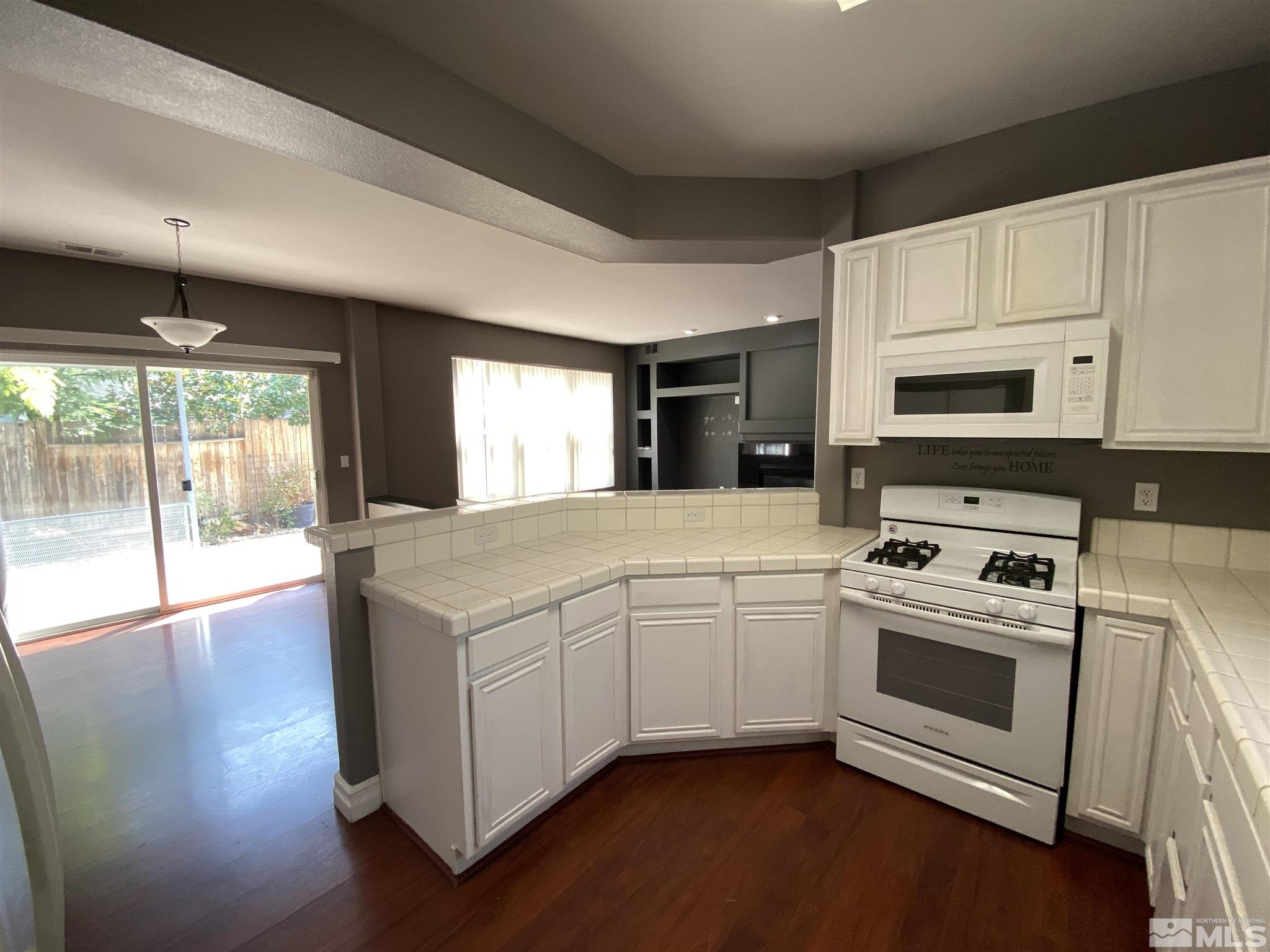 9636 Truckee Meadows Place Reno, NV 89521 - Photo 4 of 21 a kitchen with stainless steel appliances granite countertop a stove a sink and a microwave