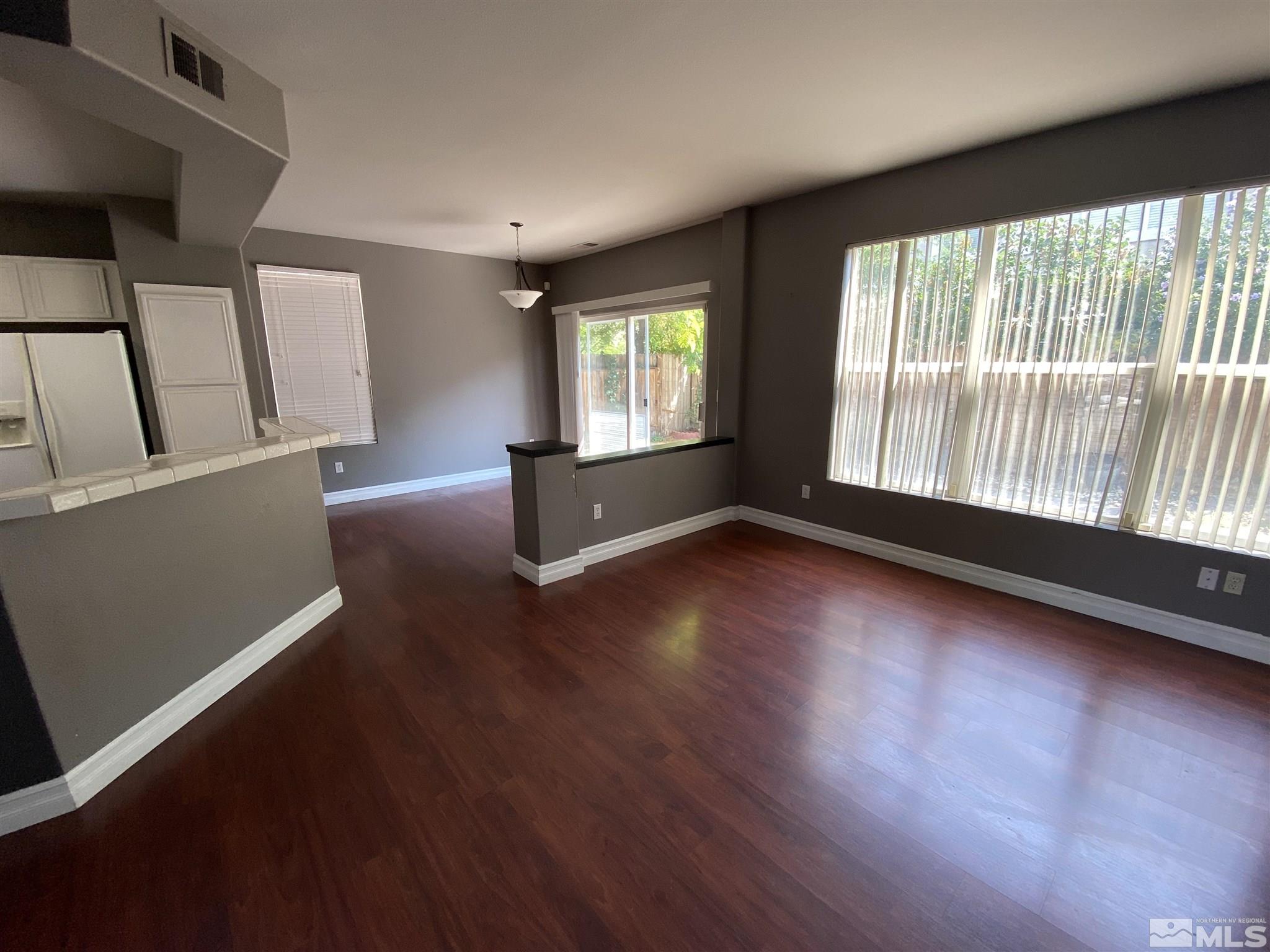 9636 Truckee Meadows Place Reno, NV 89521 - Photo 5 of 21 an empty room with wooden floor and windows