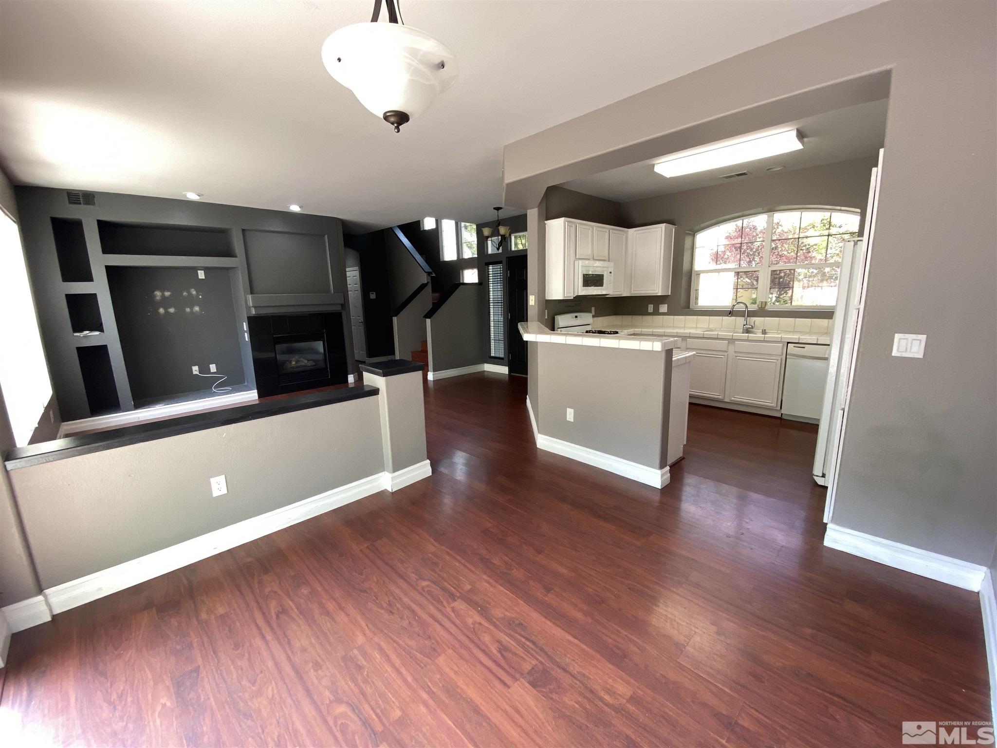 9636 Truckee Meadows Place Reno, NV 89521 - Photo 6 of 21 a view of a big room with wooden floor and a kitchen