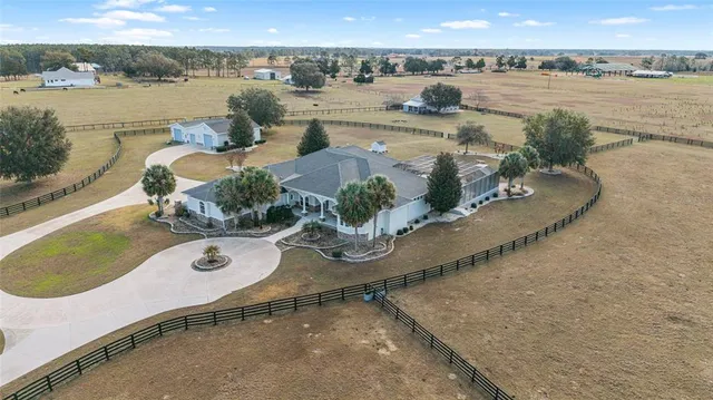 a living room with furniture and a dining table with wooden floor