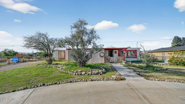a front view of a house with a garden and tree