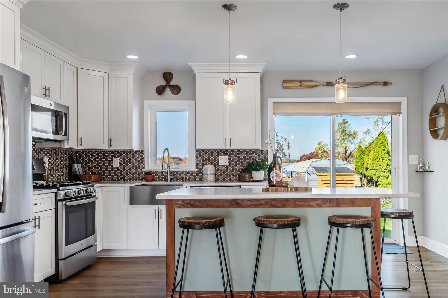 6934 River Drive Road Sparrows Point, MD 21219 - Photo 14 of 47 a kitchen with kitchen island a stove a sink and a refrigerator