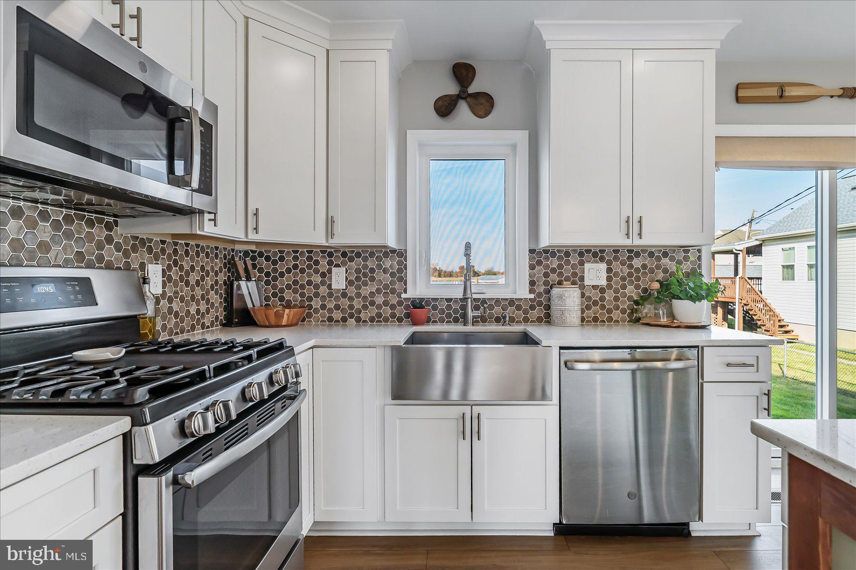 6934 River Drive Road Sparrows Point, MD 21219 - Photo 15 of 47 a kitchen with stainless steel appliances granite countertop a stove a sink and a microwave