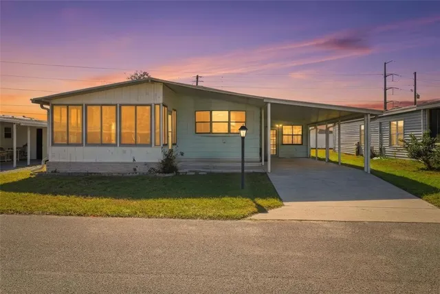 a view of a house with a patio and a yard