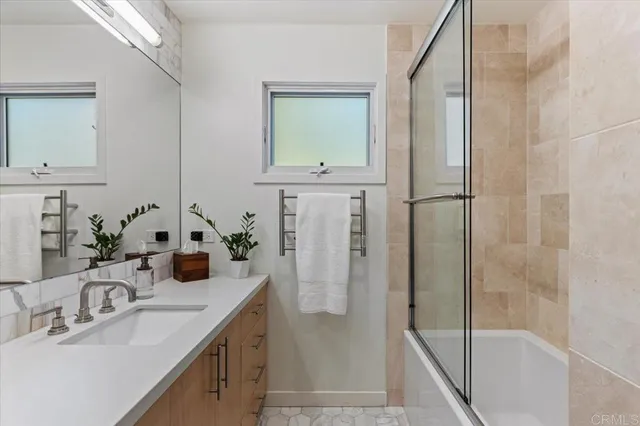 a bathroom with a granite countertop sink a mirror and shower