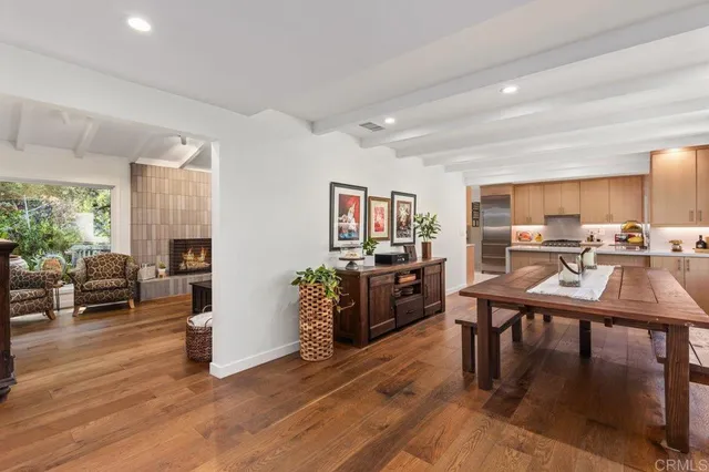 a living room with furniture dining table a window and a kitchen view