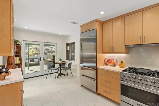 a kitchen with a stove a refrigerator and wooden cabinets