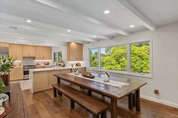 a kitchen with a table chairs sink and wooden floor