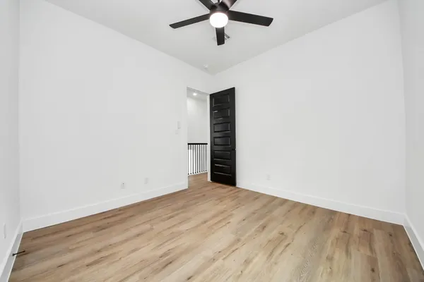 an empty room with a ceiling fan and window