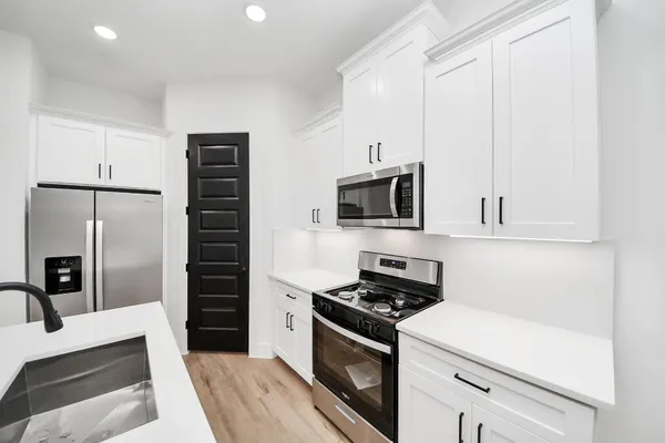 a kitchen with stainless steel appliances a refrigerator stove and microwave