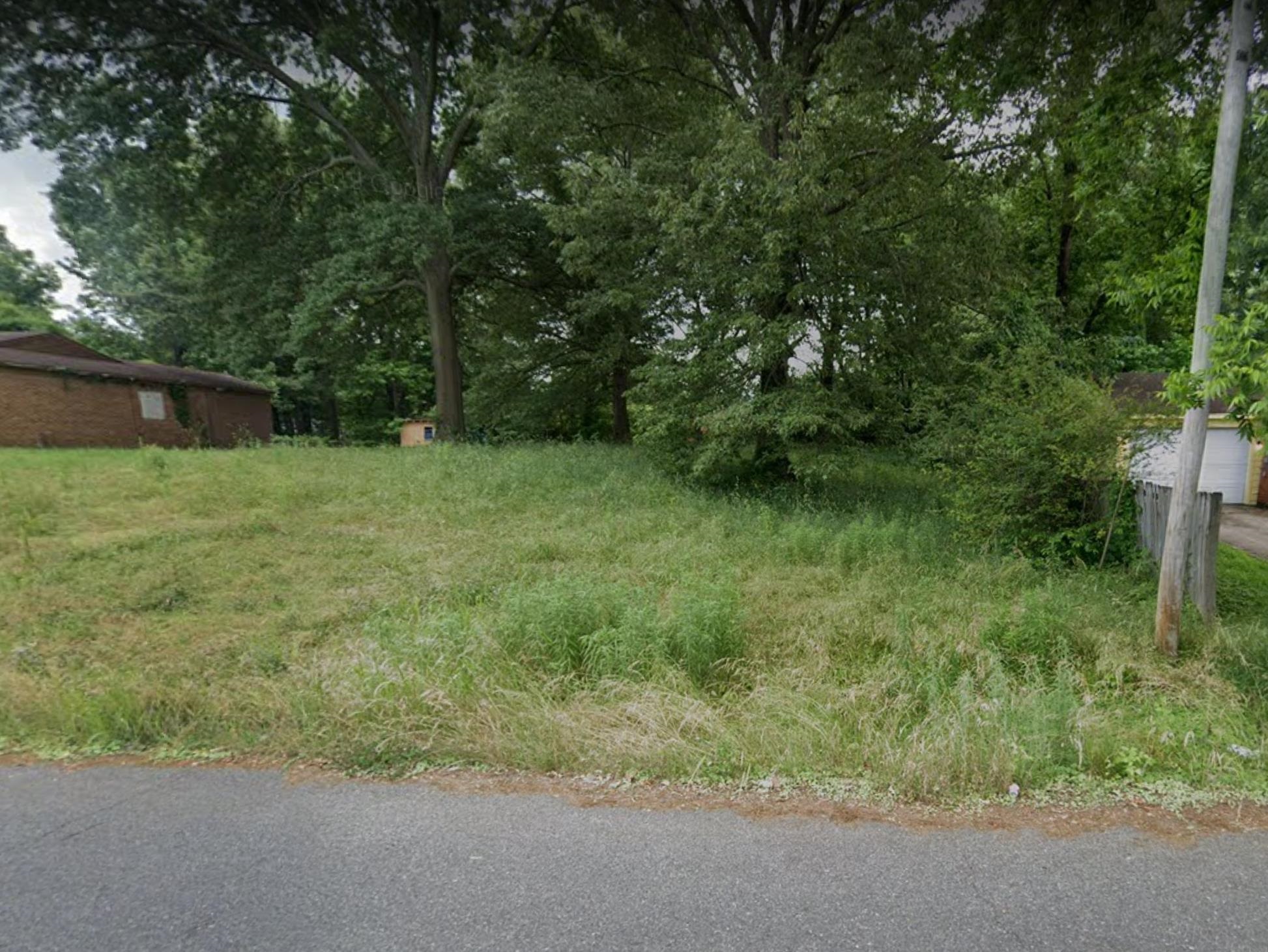 309 Delta Road Memphis, TN 38109 - Photo 1 of 2 a backyard of a house with plants and large trees