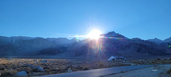 a view of a mountain with sunset in background