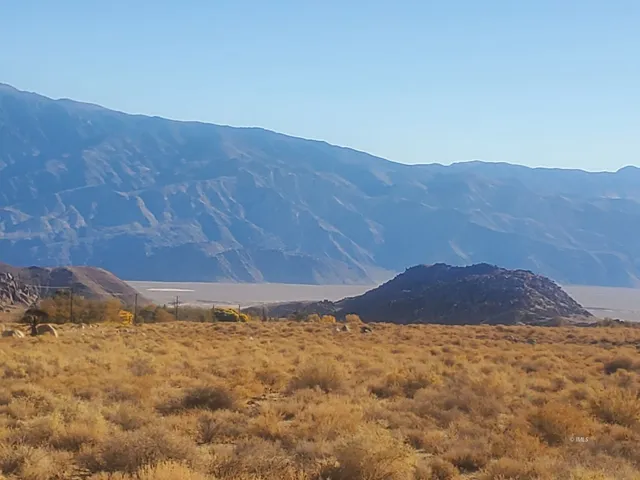 a view of a dry yard with mountain view