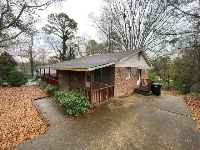 a view of a house with a yard and large tree