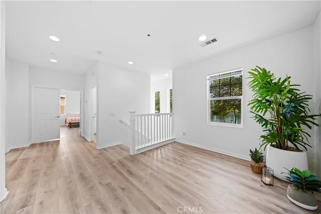 a view of a room with wooden floor and potted plant