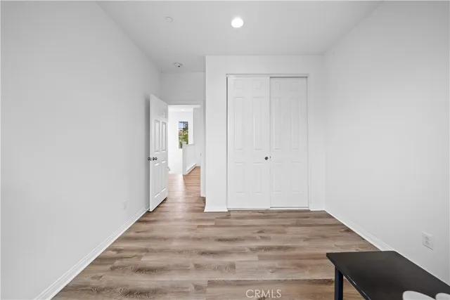 a view of a room with wooden floor and white walls