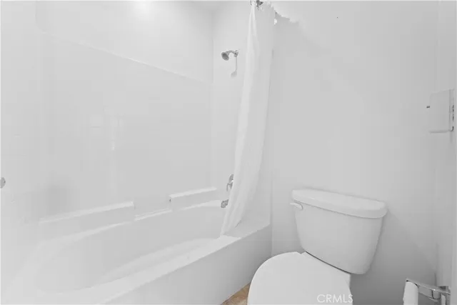 a white toilet sitting next to a bath tub