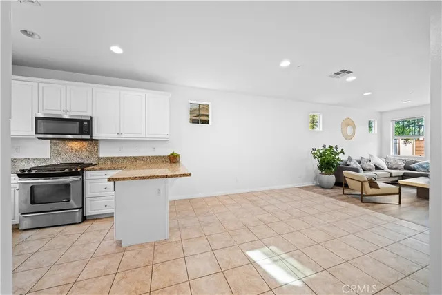 a kitchen with stainless steel appliances a stove a sink a microwave a counter top space and cabinets