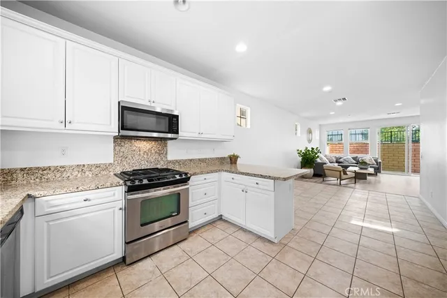 a kitchen with white cabinets a sink and appliances