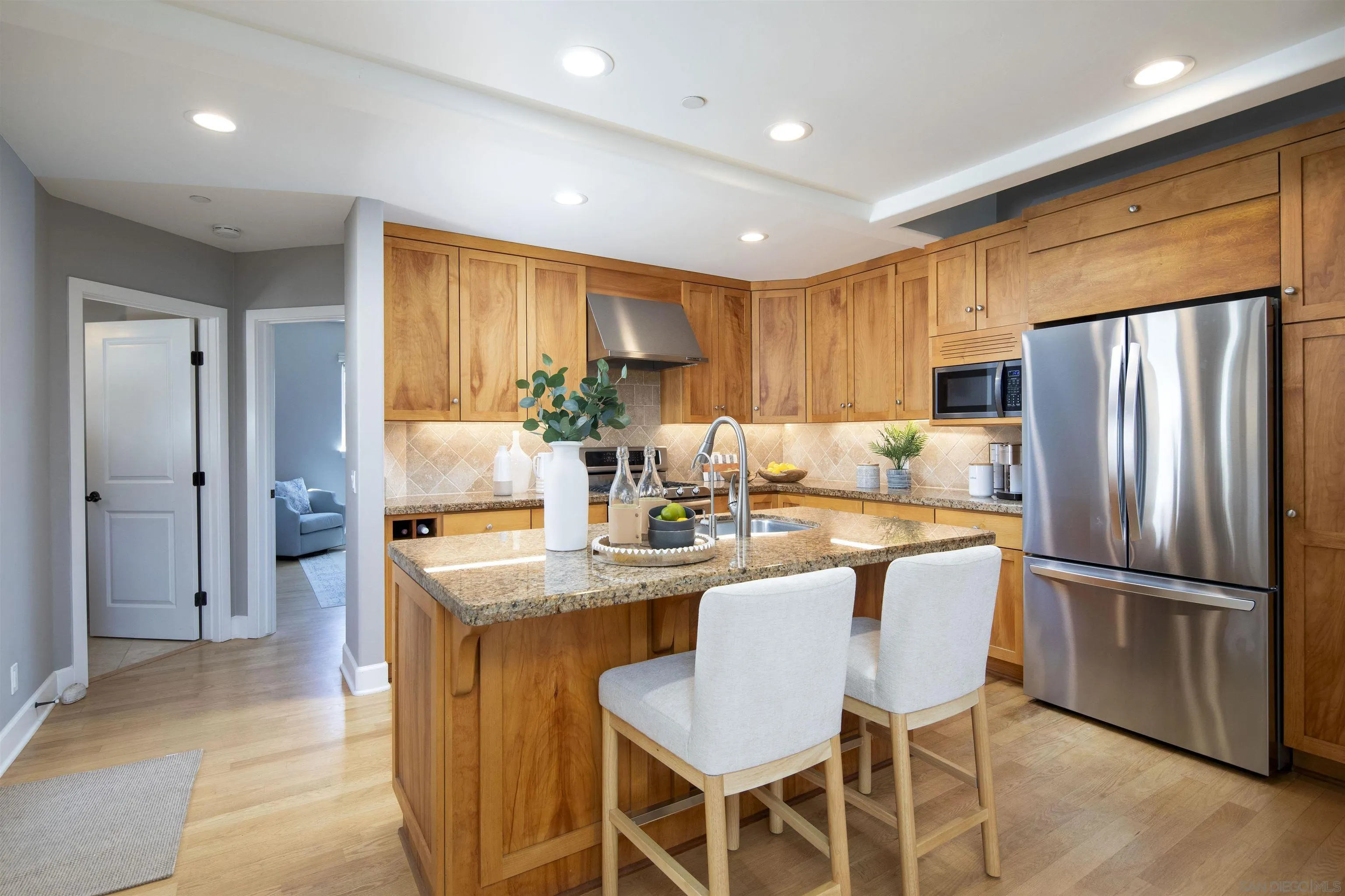 145 3rd Street Encinitas, CA 92024 - Photo 19 of 34 a kitchen with stainless steel appliances granite countertop a refrigerator a sink dishwasher a dining table and chairs with wooden floor