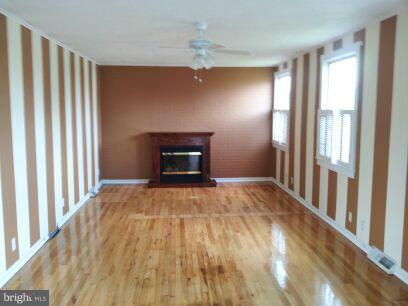 3116 Sollers Point Road Baltimore, MD 21222 - Photo 3 of 8 a view of empty room with wooden floor and fan