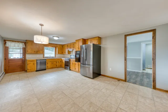 a kitchen with granite countertop a refrigerator a sink a stove and island