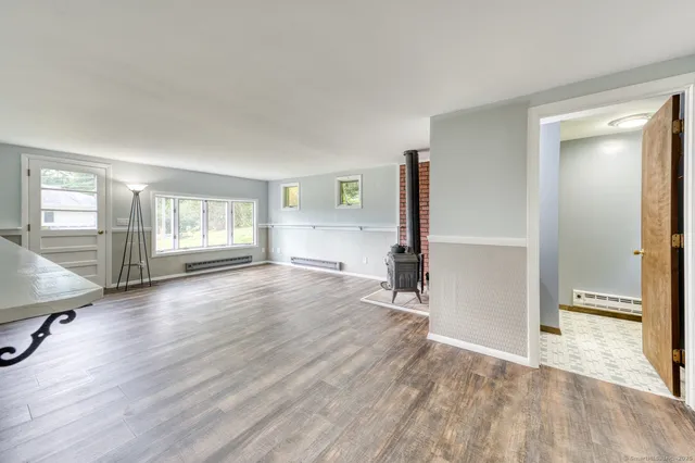 a view of an empty room with window and wooden floor