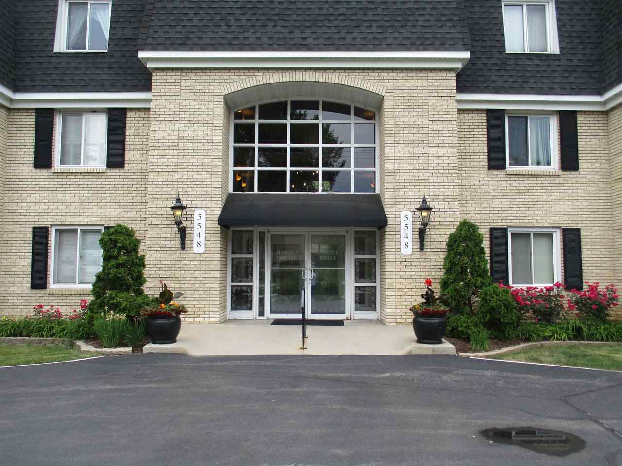 5548 Spring Brook Road, Unit G1 Rockford, IL 61114 - Photo 2 of 15 a front view of a house with a garden