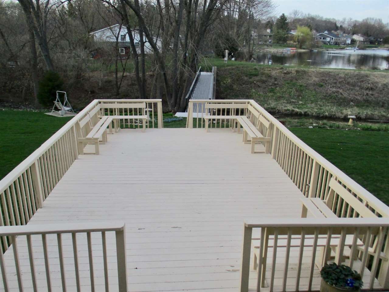 5548 Spring Brook Road, Unit G1 Rockford, IL 61114 - Photo 5 of 15 a view of a wooden deck and lake with trees in the background