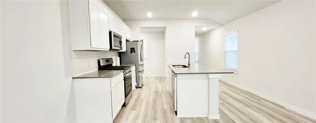 a kitchen with stainless steel appliances a refrigerator and a stove