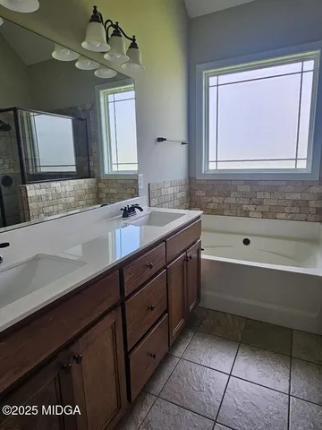 a bathroom with a tub sink and mirror