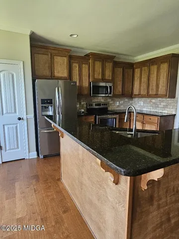 a kitchen with granite countertop a sink a counter top space appliances and cabinets