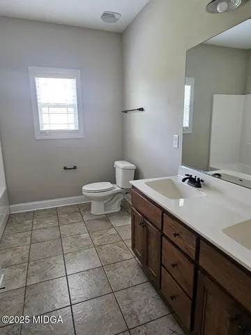 a bathroom with a sink a toilet and mirror