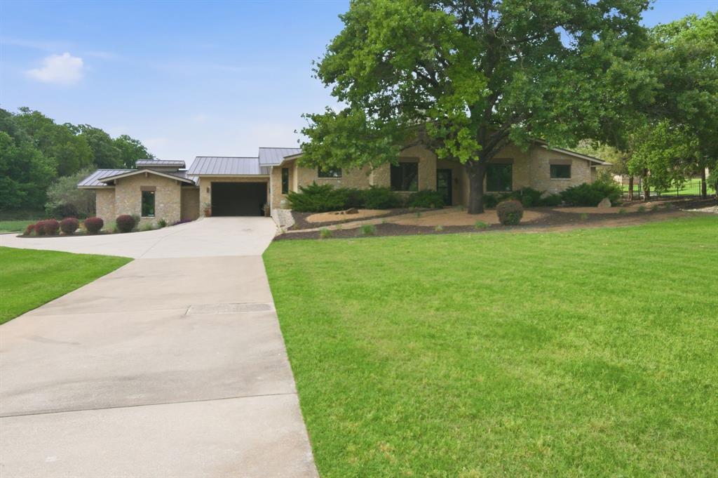 1138 Bancroft Road Keller, TX 76248 - Photo 3 of 39 Stone exterior residence featuring a metal roof, an attached garage, a paved driveway, and mature landscaping
